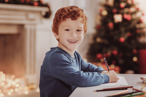 Portrait of joyful boy being busy with drawing - Foto, afbeelding
