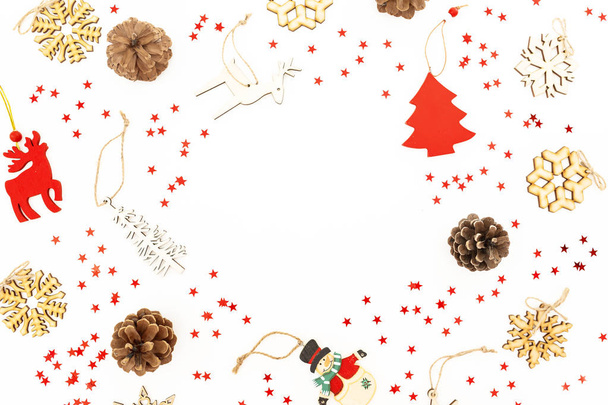 Рождественская рамка с новогодними украшениями, красные конфетти и сосновые шишки на белом. Квартира лежала, вид сверху. Новогодняя концепция
 - Фото, изображение