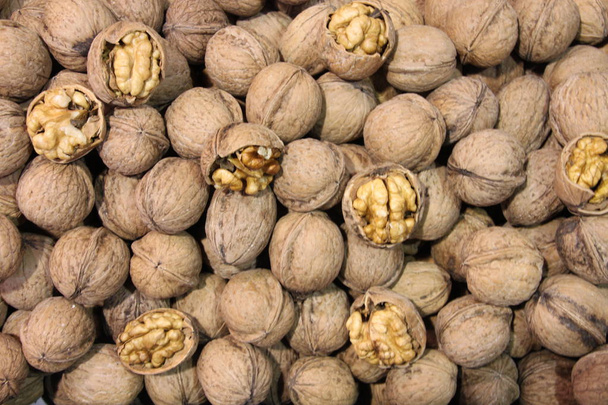Lot of whole walnuts with some cracked ones on market - Photo, Image