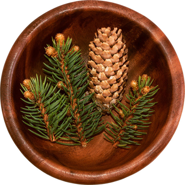 Pinecone e ramoscelli di abete in una ciotola rotonda di legno vista dall'alto su un whit
 - Foto, immagini