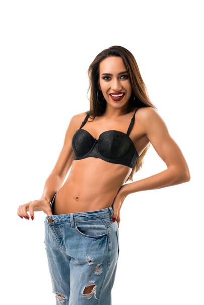 Happy girl in black bra and jeans isolated shot - Photo, image