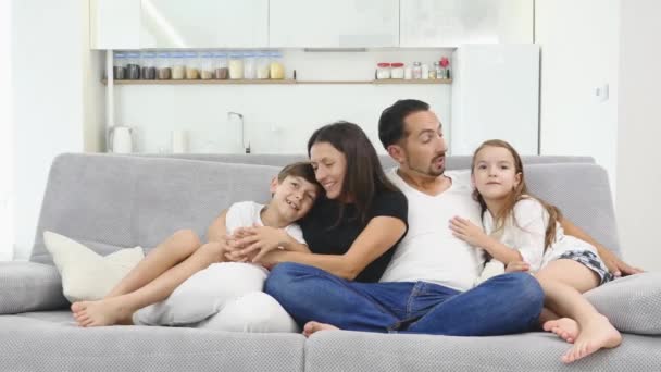 幸せな家族がテレビを見ながらソファに座って - 映像、動画