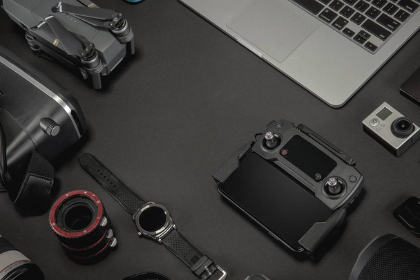 Work space photographer with laptop, digital camera, memory card, action camera, drone, remote controller, phone, VR glasses and camera accessory. Top view on black table background. Concept of mockup template. - Valokuva, kuva