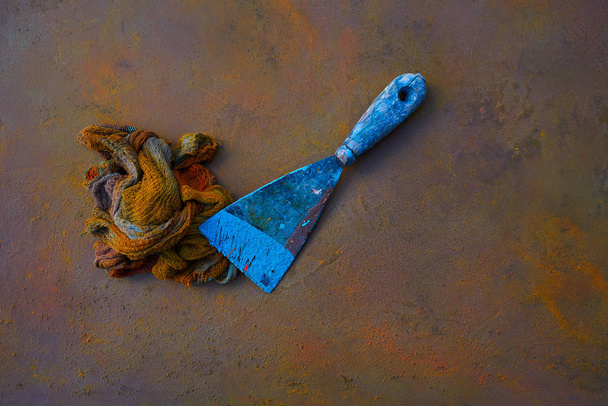 Spatula and colorful rag on oxide painted background - Foto, imagen