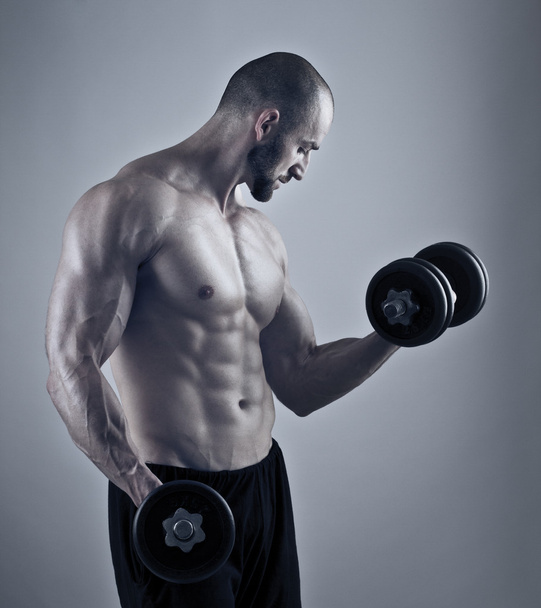 Muscular hombre entrenamiento con mancuernas
 - Foto, Imagen