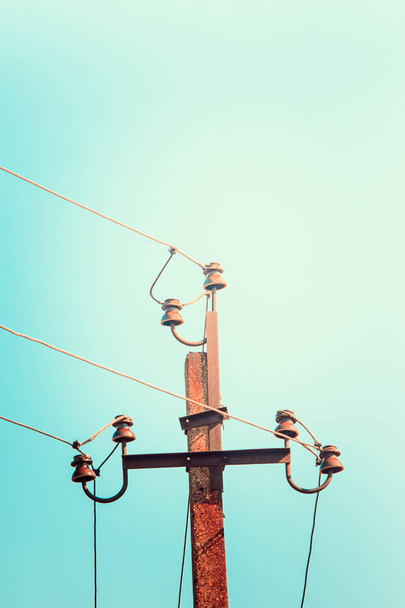 top old electrical pillar on a background of the blue sky. - Photo, Image