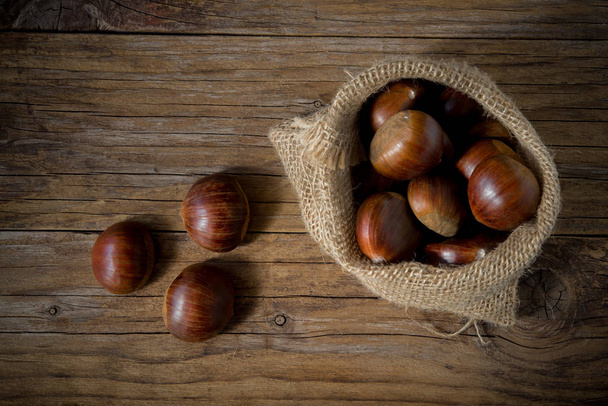 chestnuts in the sack on wooden table - Photo, Image