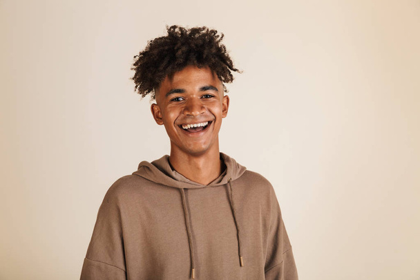 Portrait of a smiling young afro american man dressed in hoodie isolated - Foto, Imagen