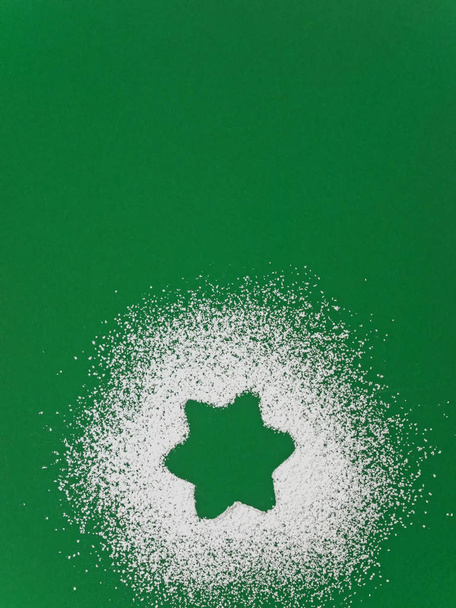 Звезда из сахарного порошка на зеленом фоне
 - Фото, изображение