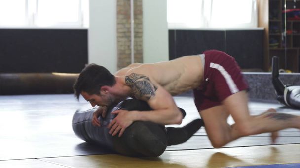 Shirtless mužské zápasník nebo drapák dělat boční kontrolu pohybu vrtáku - Fotografie, Obrázek