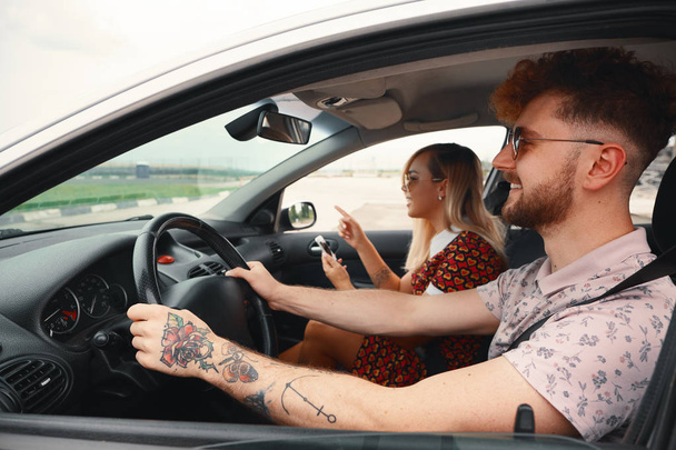 Viaggio su strada, viaggi, vacanze estive, tecnologia e persone - felice uomo e donna alla guida di auto e con navigatore GPS
  - Foto, immagini
