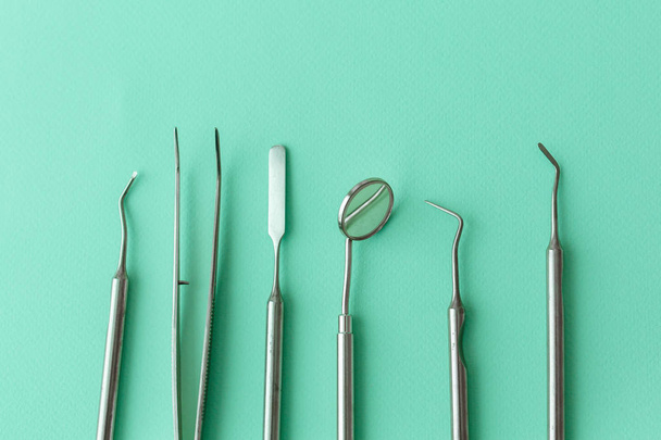 Professional Dentist tools in dental office: dentist mirror, forceps curved, explorer curved, dental explorer angular and explorer curved with chip, right. Dental Hygiene and Health conceptual image - Foto, Bild