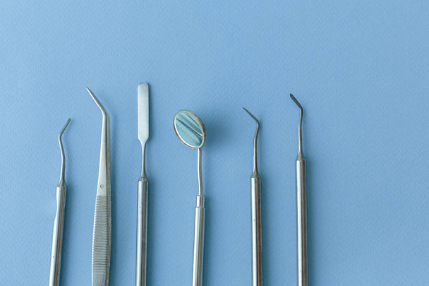 Professional Dentist tools in dental office: dentist mirror, forceps curved, explorer curved, dental explorer angular and explorer curved with chip, right. Dental Hygiene and Health conceptual image - Foto, afbeelding