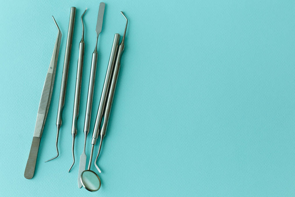 Professional Dentist tools in dental office: dentist mirror, forceps curved, explorer curved, dental explorer angular and explorer curved with chip, right. Dental Hygiene and Health conceptual image - Photo, Image