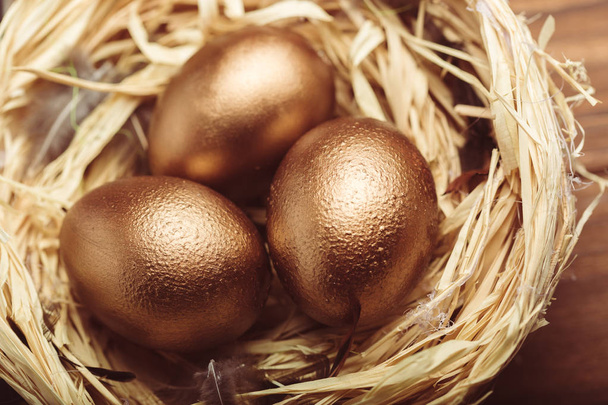 closeup of gold eggs on wooden table - Zdjęcie, obraz