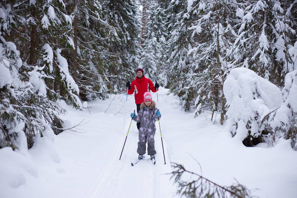Mężczyzna i dziecko narciarskich zimą w lesie - Zdjęcie, obraz