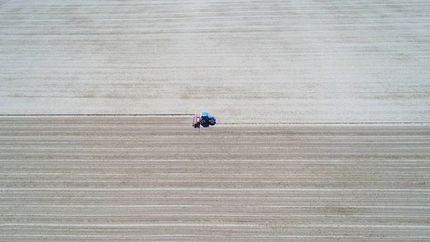Ilmakuva peltoa kyntävästä traktorista
 - Valokuva, kuva