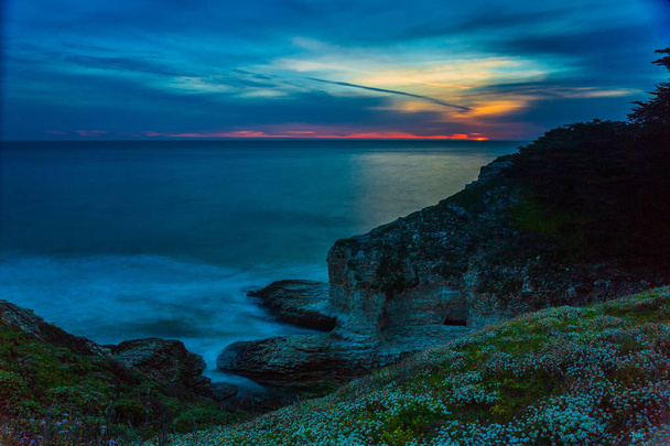 Photo longue exposition des vagues et des roches le long de la côte californienne au coucher du soleil
 - Photo, image