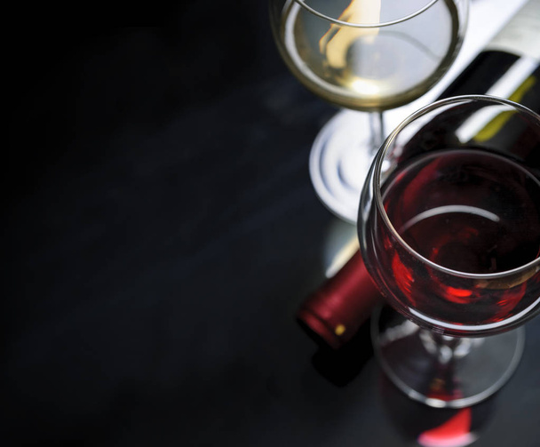 赤と白の黒の背景にワインのガラス。Copyspace ワイン リスト デザイン メニュー。アルコール飲料のカード背景. - 写真・画像