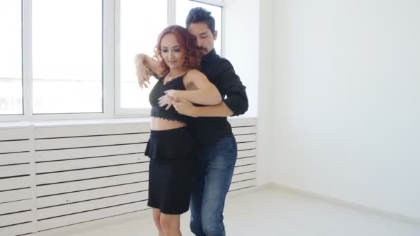 Young couple dancing social dancing kizomba or bachata or semba in dancing class indoors - Footage, Video