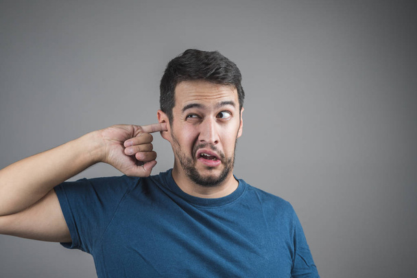 mladý muž výdeje ucho s prstem - Fotografie, Obrázek