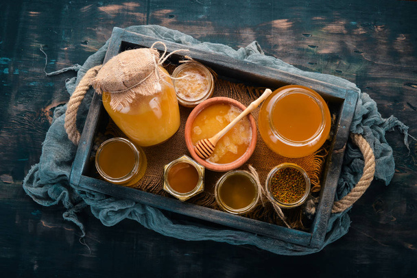 Set honey in a wooden box on a wooden background. Free space for text. Top view. - Photo, Image