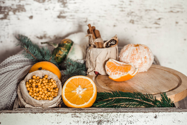 Still life with orange and sea buckthorn on a wooden background, concept of seasonal vitamins and healthy eating. - Photo, Image