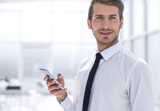 close up.smiling businessman with smartphone - Zdjęcie, obraz