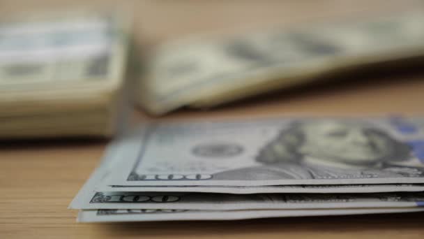 Zbliżenie: businessmans ręce licząc stu dolarowych przy stole - Materiał filmowy, wideo