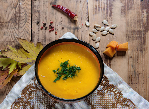 Flat lay pumpkin soup bowl on rustic wooden background - Foto, afbeelding
