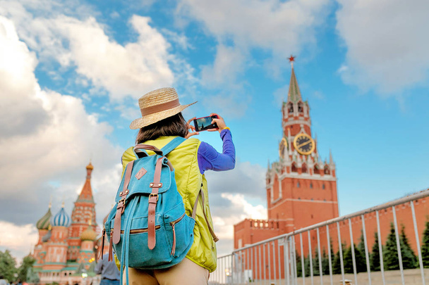 Νεαρός ταξιδιώτης γυναίκα λήψη φωτογραφιών χρησιμοποιώντας το smartphone στην Κόκκινη Πλατεία στη Μόσχα, Ρωσία - Φωτογραφία, εικόνα