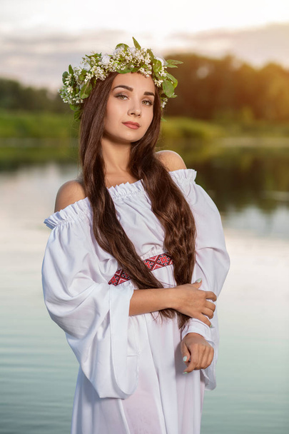 Frau in weißem Kleid im Wasser. Kunstfrau mit Kranz auf dem Kopf im Fluss. Kranz auf dem Kopf, slawische Traditionen und Heidentum - Foto, Bild