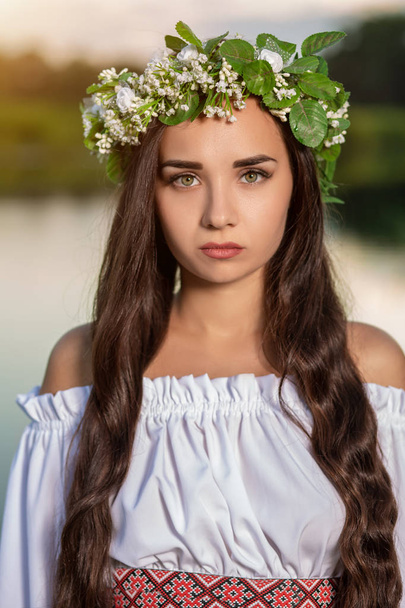 Woman in white dress in the water. Art Woman with wreath on her head in river. Wreath on her head, Slavic traditions and paganism - Foto, immagini