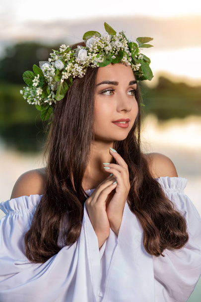 Woman in white dress in the water. Art Woman with wreath on her head in river. Wreath on her head, Slavic traditions and paganism - Fotoğraf, Görsel