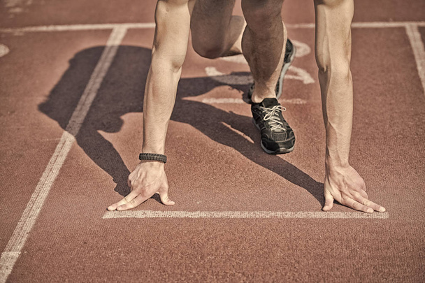 man runner with muscular hands, legs start on running track - Фото, изображение