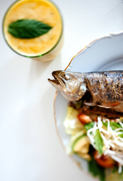 Lezzetli pişmiş alabalık balık biyo organik salata ile yukarıdan görünüm ve nane yaprağı ile limonata bardak - Fotoğraf, Görsel