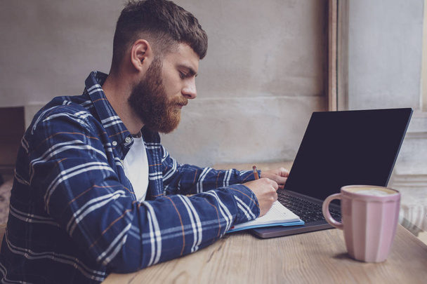 Young man chatting via net-book during work break in coffee shop - Zdjęcie, obraz