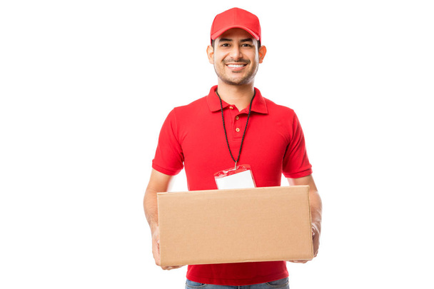 Portret van glimlachen mannelijke vervoeren leveringspakket op witte achtergrond - Foto, afbeelding