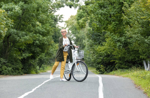 Hermosa mujer en traje casual con bicicleta al aire libre
 - Foto, Imagen