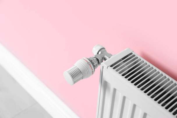 Radiatore di riscaldamento con termostato vicino alla parete a colori
 - Foto, immagini