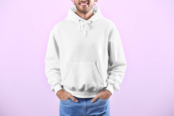 Man in hoodie sweater on color background. Space for design - Fotografie, Obrázek