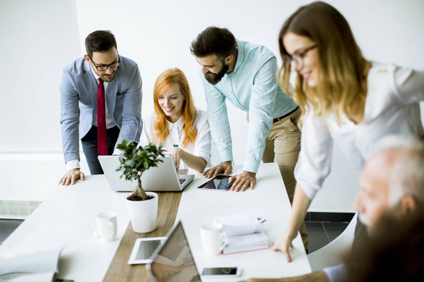 Bekijken van mensen uit het bedrijfsleven een strategie te bespreken en samen te werken in het moderne kantoor - Foto, afbeelding