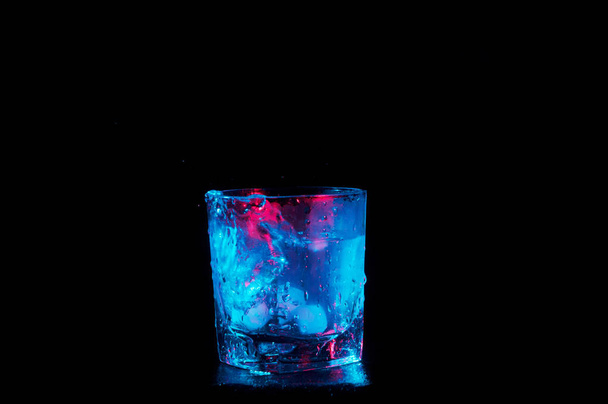 ледяная вода в скалах стекло под красочные огни изолированы на черном фоне
 - Фото, изображение