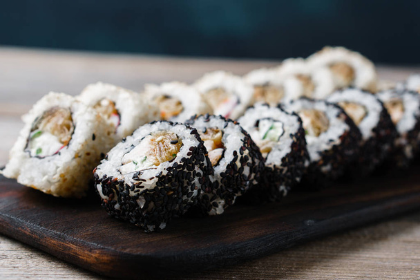  rolos de sushi com carne de caranguejo, cobertos com gergelim
 - Foto, Imagem