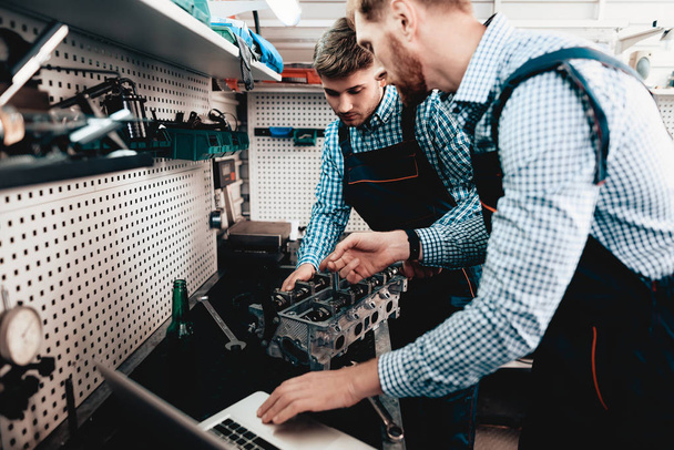 Two Auto Mechanics Work Together In Garage. Wrench Using. Laptop Screen Staring. Information Sharing. Professional Uniform. Confident Engineering Specialist Team. Service Station Concept. - Foto, Bild