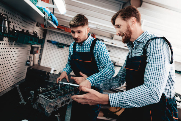 Two Mechanics Conversation In The Garage. Wrench Using. Arguing Colleagues. Information Sharing. Professional Uniform. Confident Engineering Specialist Team. Service Station Concept. - Photo, Image