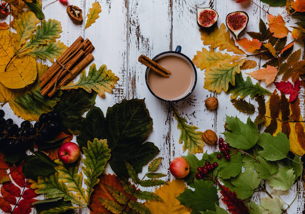 Κάτοψη του άρωμα καφέ με κανέλα σε ξύλινα φόντο με φθινόπωρο φύλλα, μήλα και σύκα  - Φωτογραφία, εικόνα