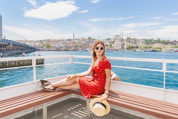 Όμορφη γυναίκα κρουαζιέρες σε πλοίο με θέα γέφυρα του Γαλατά, Τζαμί Σουλεϊμάνιγιε και Eminonu πόλη Κωνσταντινούπολη, Τουρκία - Φωτογραφία, εικόνα