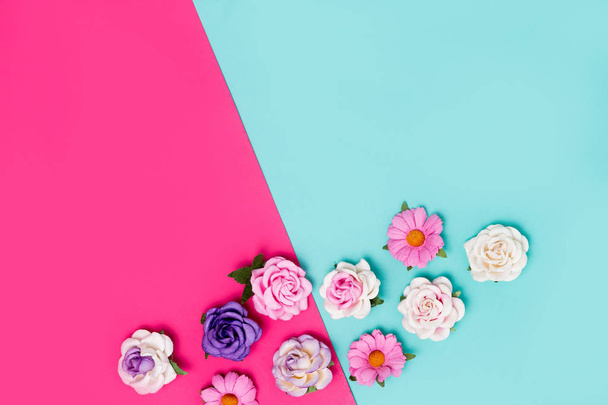 Pink, purple and white artificial roses on colorful background, top view, copy space - Photo, image