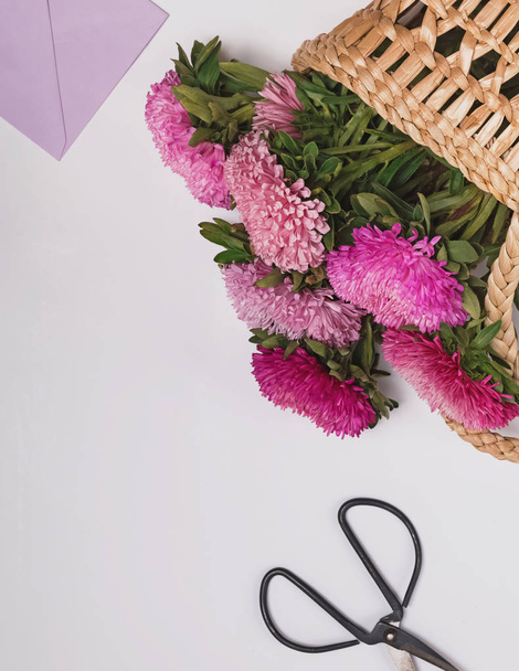 Pink flowers in a straw basket on the white background - Photo, image